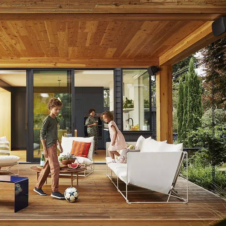 Family relaxing on a covered patio with outdoor speakers